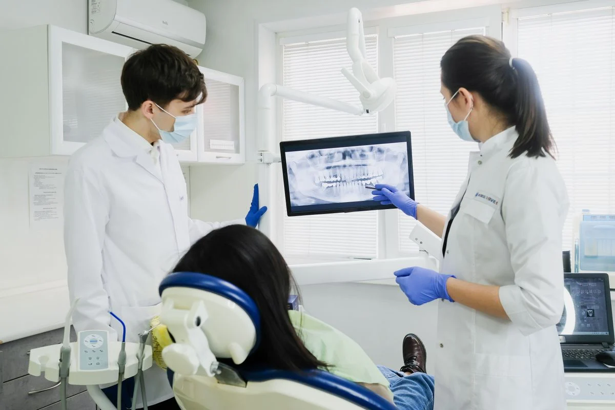 Dentists reviewing a dental X-ray before implant treatment in Turkey