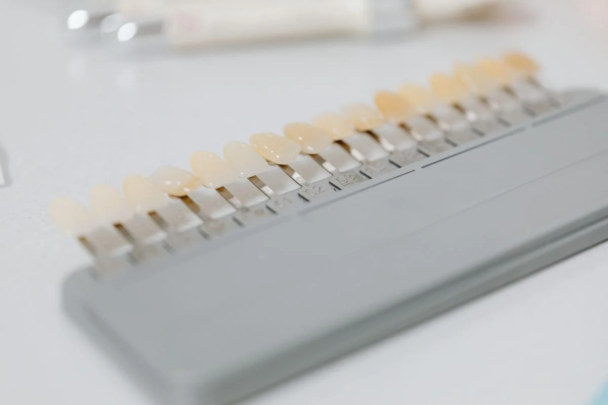 Dentist checking veneer shade against a patient smile