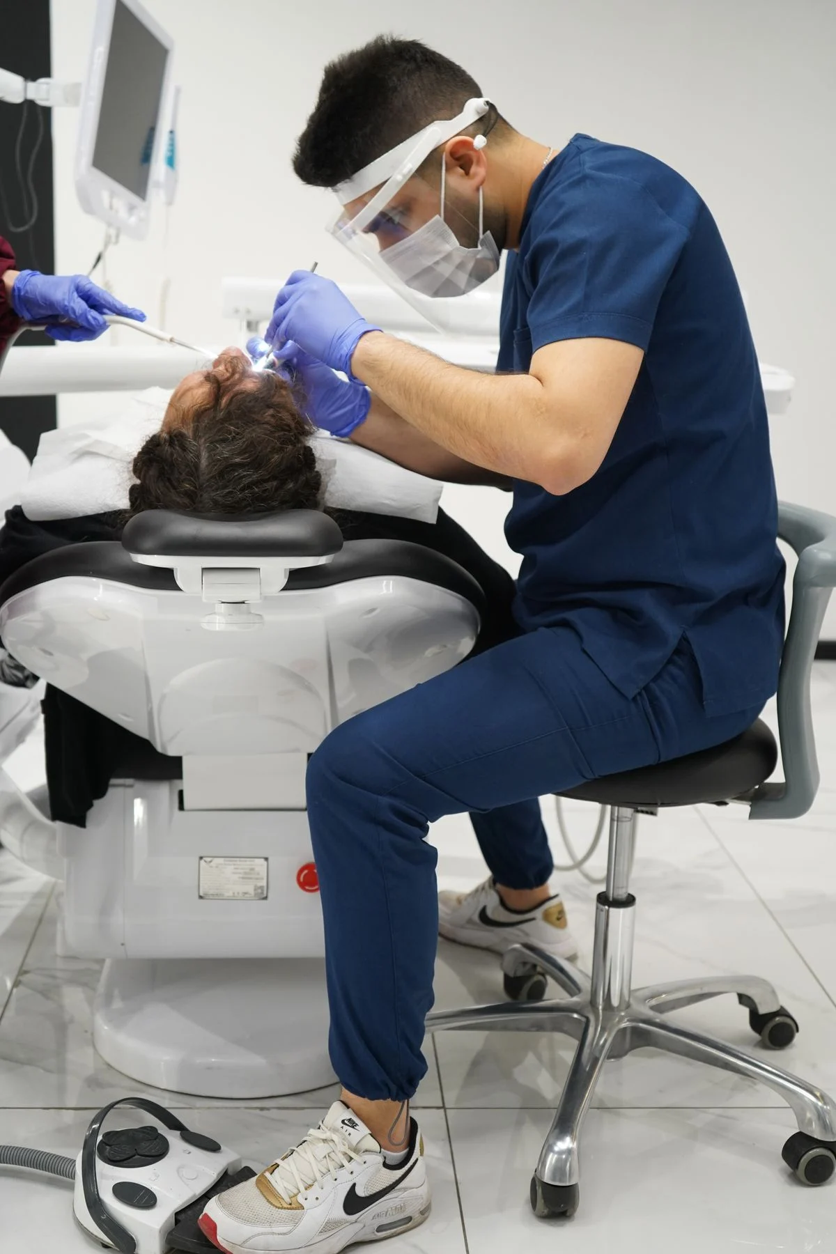 Cosmetic dentist checking veneer margins with a mirror during a follow-up